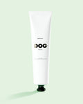 White tube labeled 'DOG' Soothing balm on a light green background