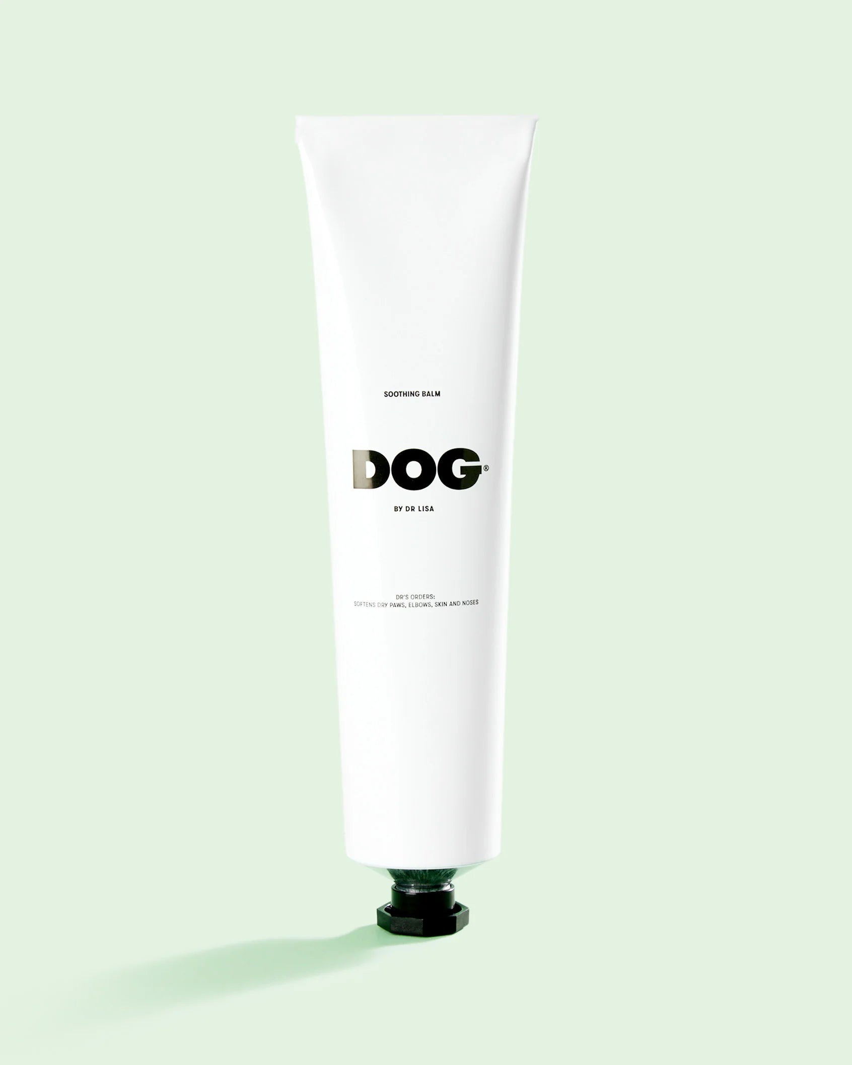 White tube labeled 'DOG' Soothing balm on a light green background