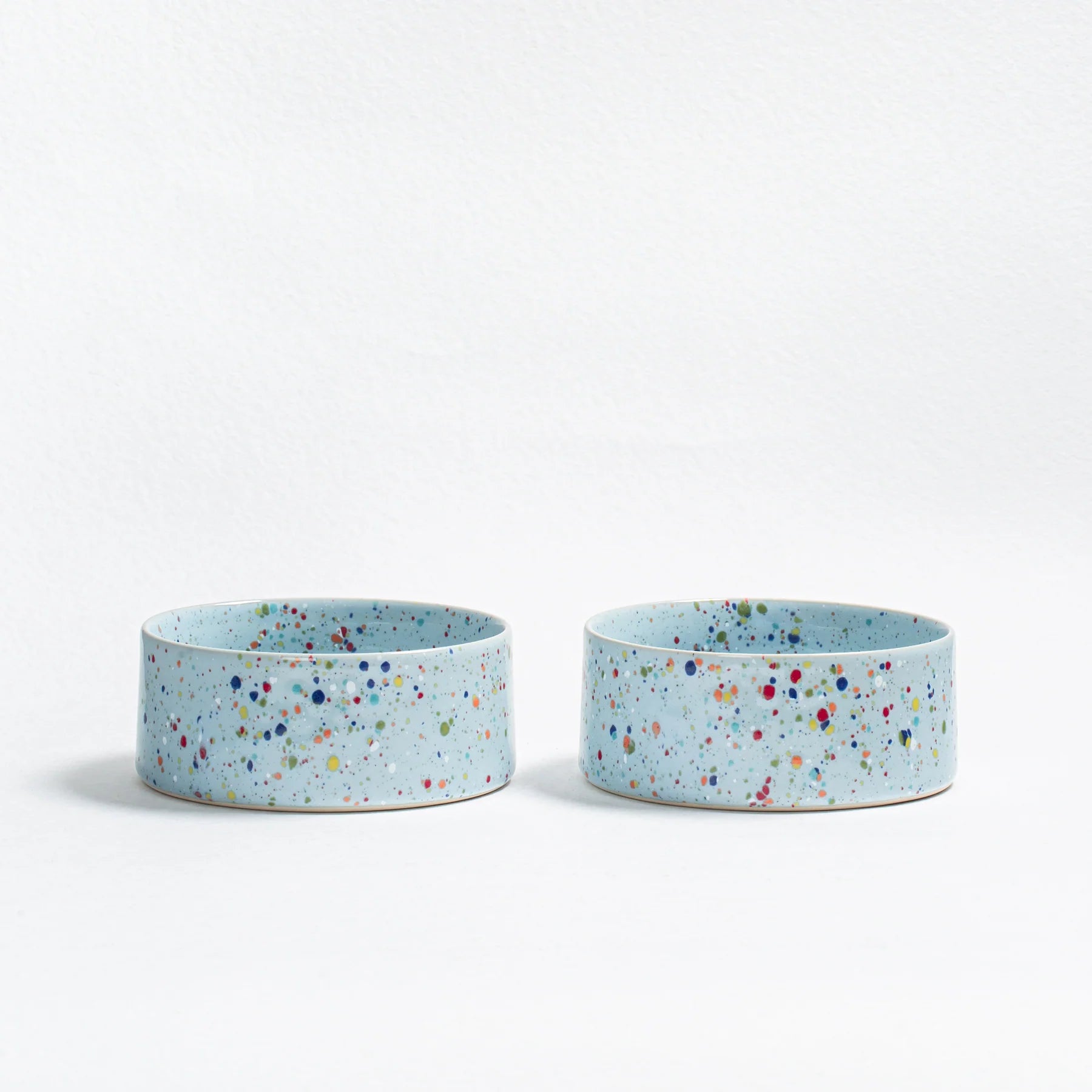 Two small blue ceramic dog bowls with a speckled pattern