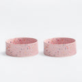 Two pink ceramic dog bowls with speckled pattern