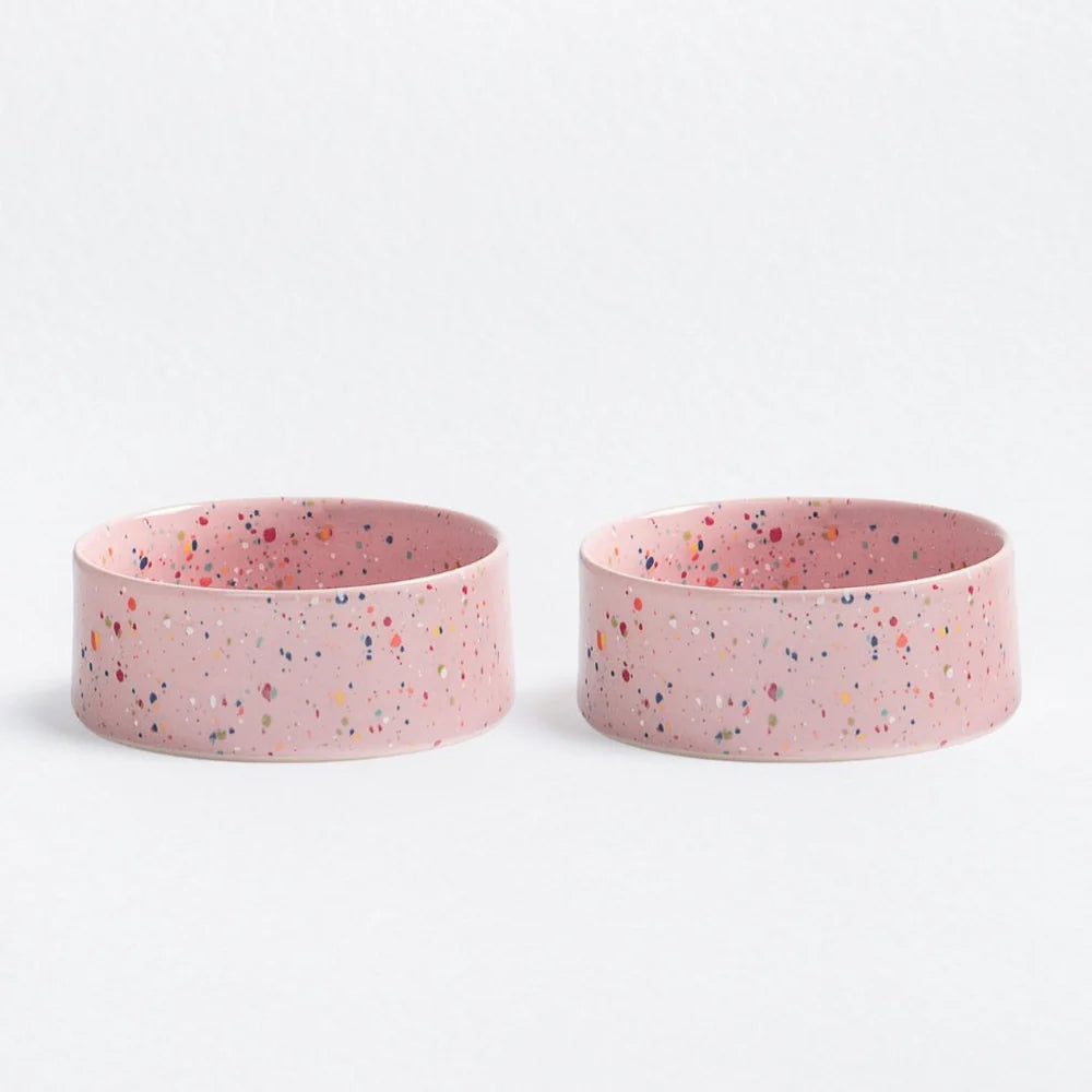 Two pink ceramic dog bowls with speckled pattern
