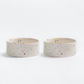 Two ceramic pet bowls with colourful speckles on a white background