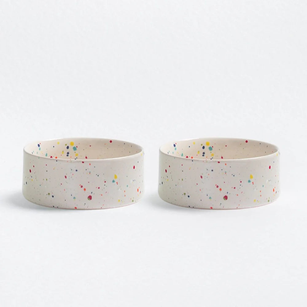 Two ceramic pet bowls with colourful speckles on a white background