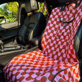 Car seat covers for dogs with a colorful pattern in a vehicle interior.
