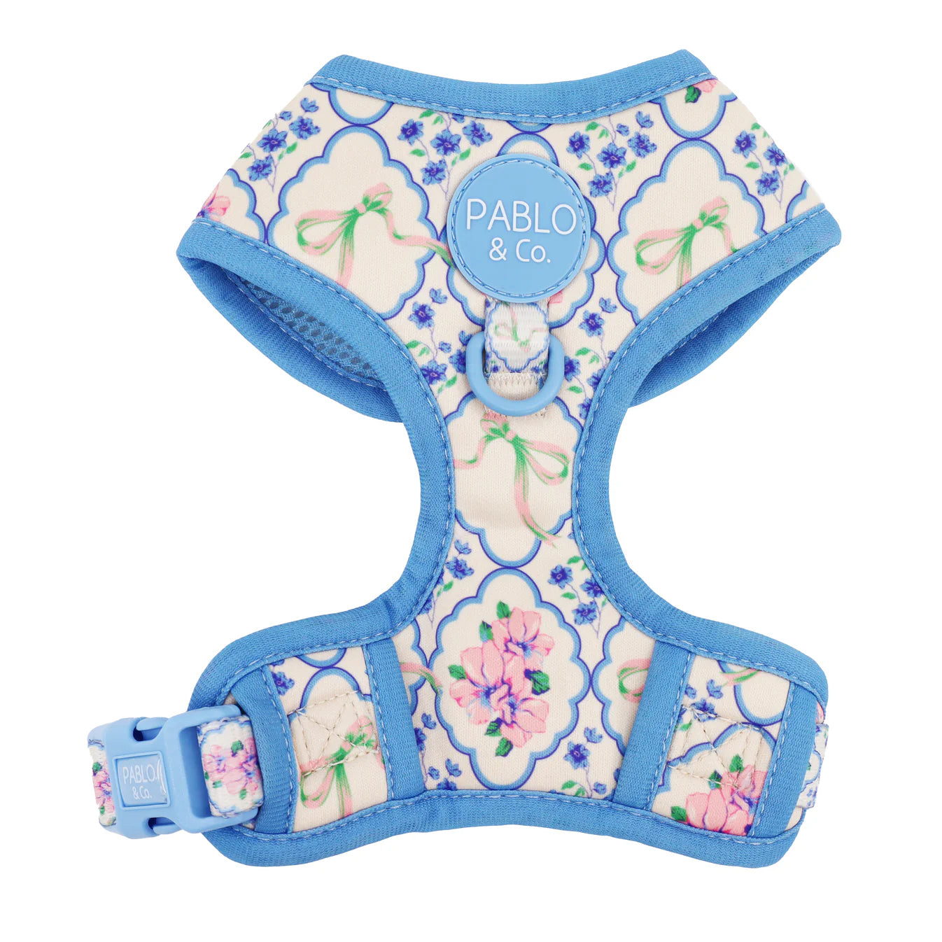 Floral patterned dog harness with blue trim on a white background