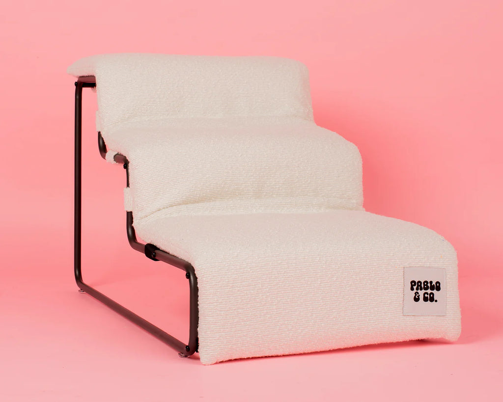 White textured pet stairs with black metal frame on a pink background