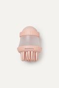 Pink dog shampoo brush with a white background
