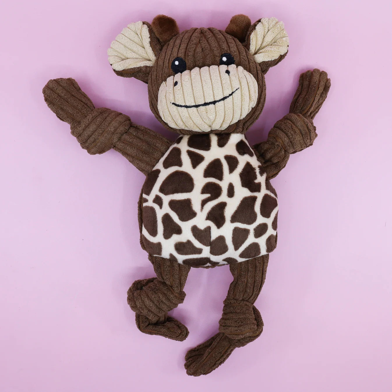 Stuffed dog toy with giraffe pattern on a pink background