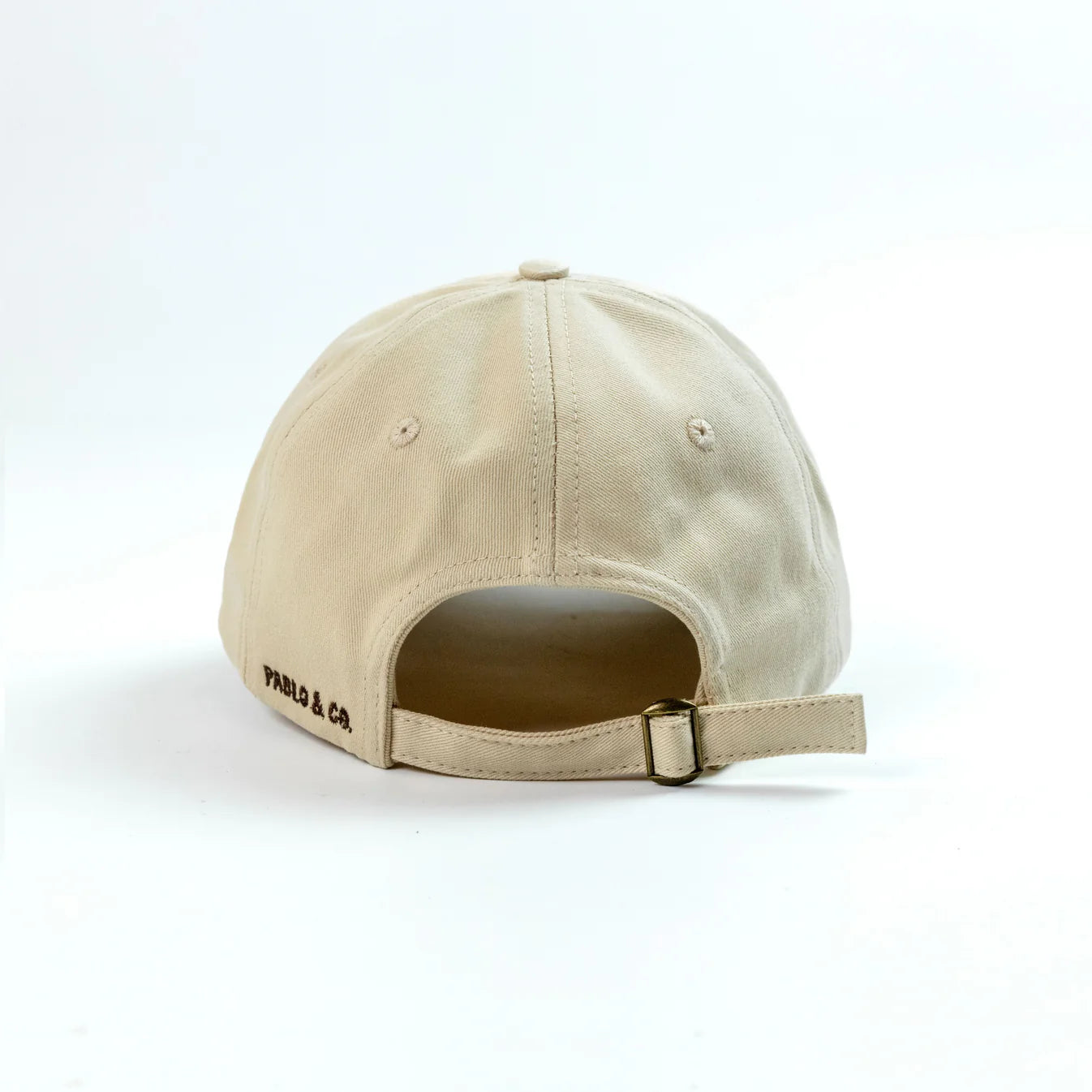 Beige cap with 'Pablo & Co' branding on a white background