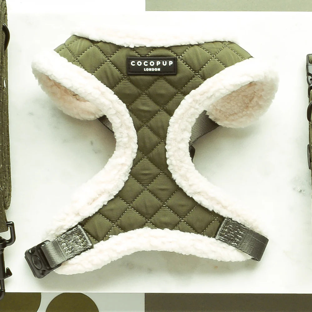 Green quilted dog harness with white fleece lining and COCOPUP branding on a white background