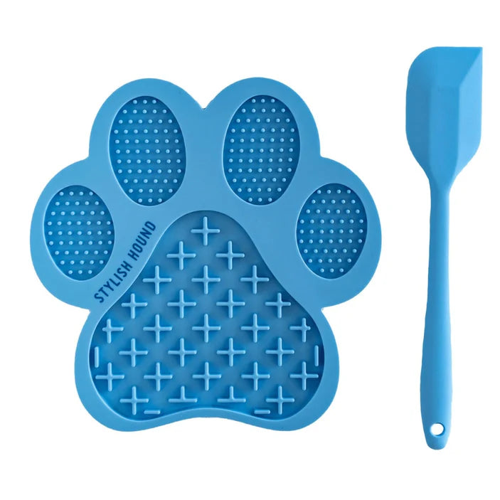 Blue paw-shaped lick mat with textured surface and a spatula