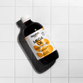 Bottle of Nourish Mega Oil on a tiled surface