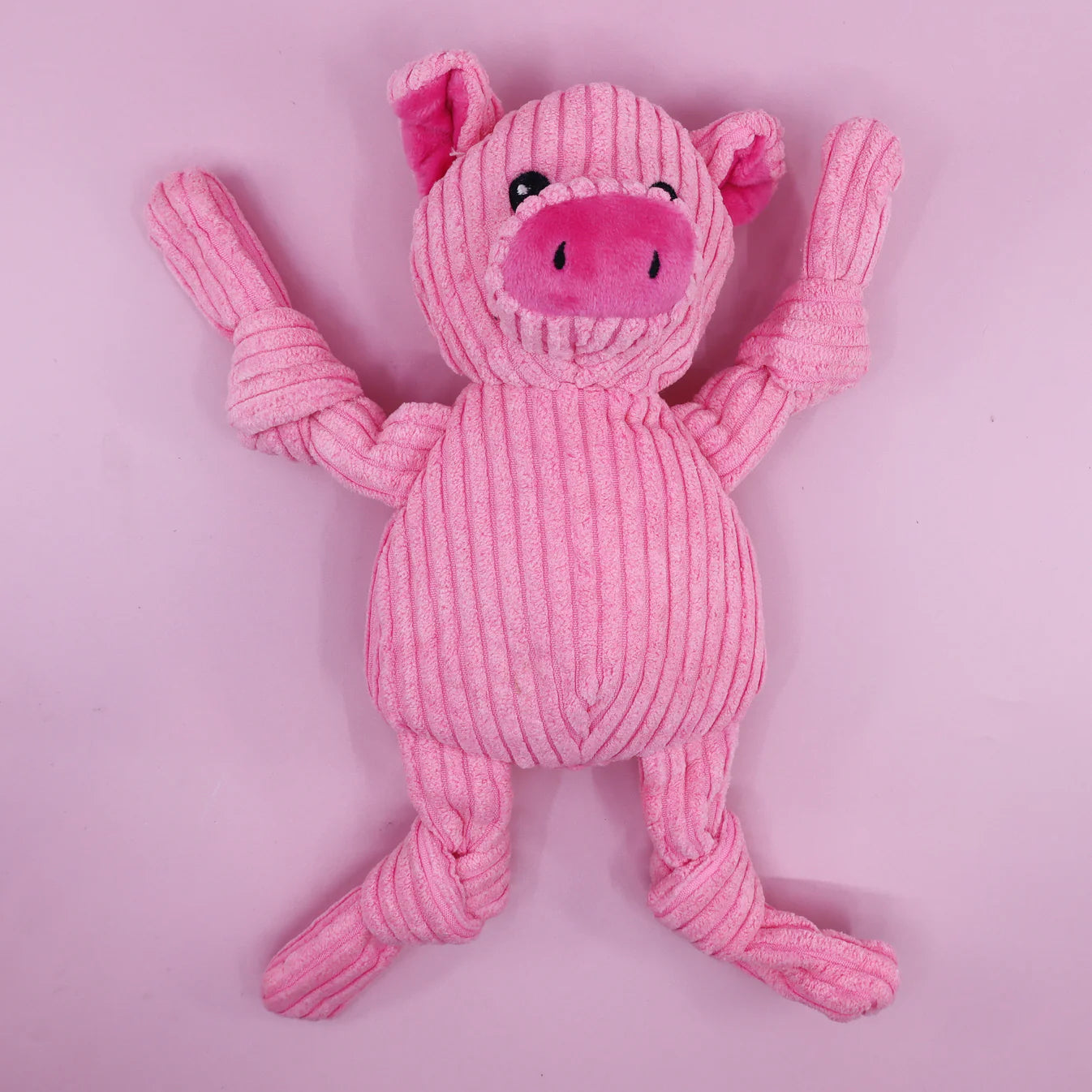 Pink plush pig dog toy on a pink background